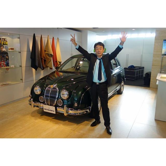 光岡自動車の光岡章夫代表取締役社長。手の指で“25”を表現している。