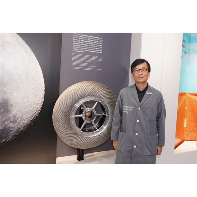 ブリヂストンイノベーションギャラリーの森 英信館長。月面探査機用タイヤとともに。